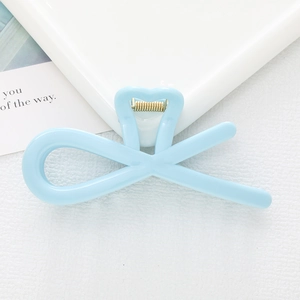 Close-up of light blue hair claw clip with cross-line design and metallic spring detail