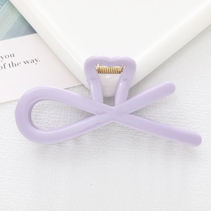 Detailed close-up of light purple heart-shaped hollow bow hair clip with golden metal spring