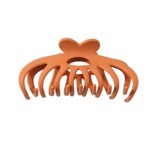 Matte orange pumpkin hair claw clip with heart-shaped handle and multi-tooth grip for thick hair