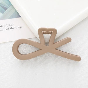 Close-up of matte coffee-brown hair claw clip with hollow heart and geometric lines