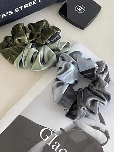 Close-up of contrast satin and velvet large hair scrunchies on lifestyle background