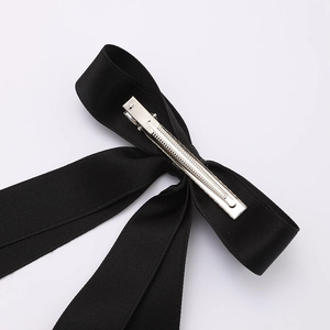 Close-up of the silver metal duckbill clip on the back of the black ribbon bow hair clip