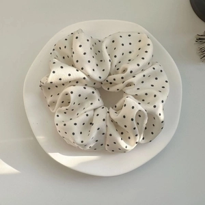Chouchou élégant à pois noirs sur une assiette en céramique blanche sous lumière naturelle
