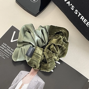 Detail of olive green scrunchie featuring mixed silk and velvet texture materials