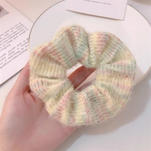 Close-up of soft mohair knit hair scrunchie with pastel pink and blue plaid patterns
