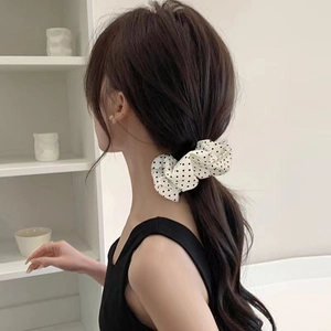 Polka dot fabric scrunchie in hair showing natural ruffles and elegant pleated texture
