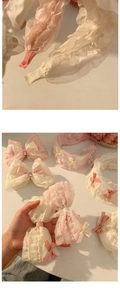 Dettaglio di fermagli per capelli con fiocco in pizzo e fascia con ruches rosa