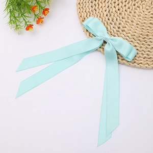 Close-up of mint blue double-layered satin bow hair clip with long flowing ribbons