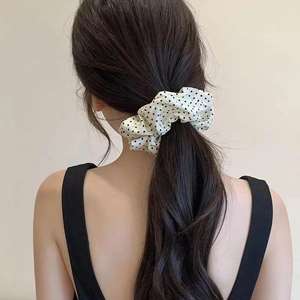 Polka dot fabric scrunchie in cream and black on hair for a retro vintage style