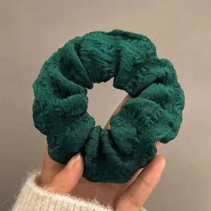 Dunkelgrüner übergroßer Scrunchie mit plissierter Textur für elegantes Haarstyling