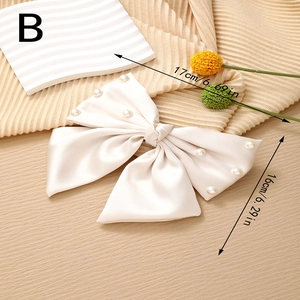 Detail view of large cream satin bow hair clip with pearls measuring 17cm by 16cm