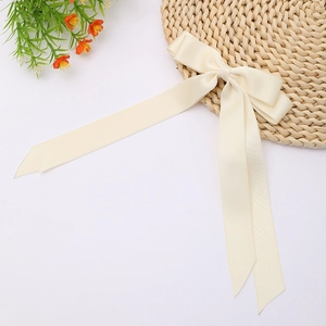 Detail view of cream double-layered satin ribbon bow with elegant long streamers