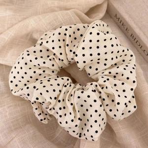 Detail shot of a cream-colored polka dot scrunchie with high-quality linen fabric texture