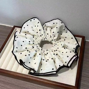 Chouchou vintage français blanc à pois avec bordure noire élégante dans un plateau en bois