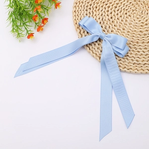Detail of light blue ribbon bow hair clip with double layers and long streamers