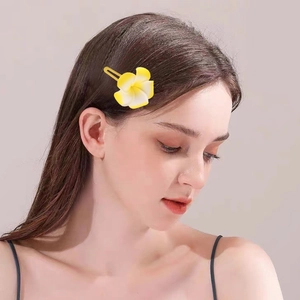 Douce pince à cheveux fleur de frangipanier tropicale jaune et blanc sur un mannequin