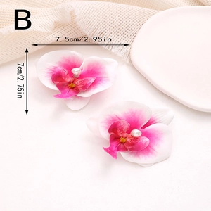 Détail des pinces à cheveux orchidée avec pétales dégradés roses et centre en perle