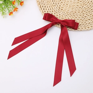 Close-up of deep red satin double-layered bow hair clip with elegant long ribbons