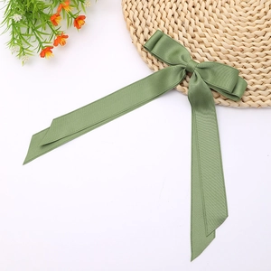Close-up of bean green double-layer satin bow hair clip with elegant long streamers