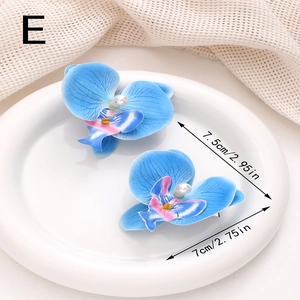 Détail de pinces à cheveux orchidée bleue avec mesures sur une assiette en céramique blanche