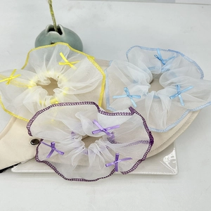 Détails de chouchous en organza bleu, jaune et violet avec de petits nœuds élégants