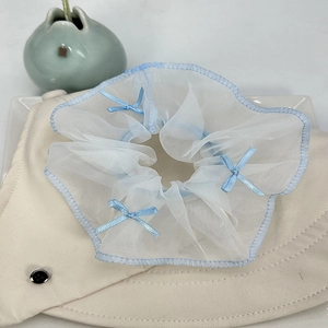 Détail du chouchou en tulle blanc avec bords bleus et petits nœuds en satin