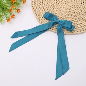 Detail of peacock blue satin hair bow with long flowing streamers for women's hairstyle