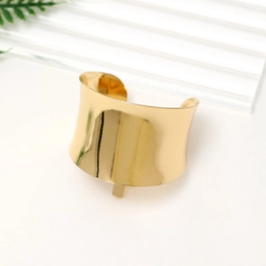 Detailed close-up of wide golden polished metal hair cuff with a mirror finish