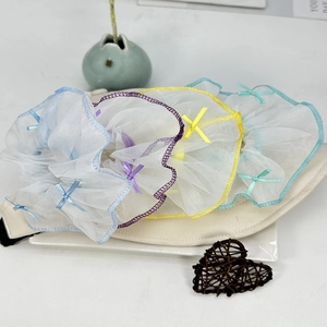 Détail de quatre chouchous en organza avec bords colorés et petits nœuds en soie