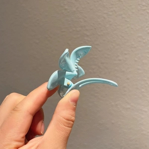 Détail de la pince à cheveux papillon bleu clair avec finition brillante et ressort