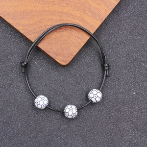 Dettaglio del bracciale regolabile in corda cerata nera con tre perline a forma di calcio