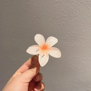 Détail d'une pince à cheveux fleurie moyenne avec dégradé orange et blanc élégant