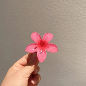 Pince à cheveux fleur de frangipanier rose translucide avec finition pailletée chic