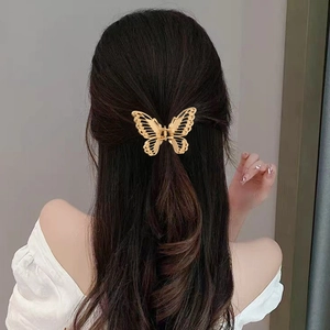 Elegant gold butterfly hollow alloy hair claw clip for women shown on dark hair
