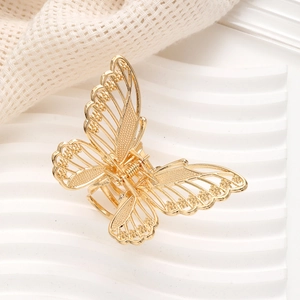 Close-up of golden hollow butterfly metal hair claw clip with delicate cutout wings