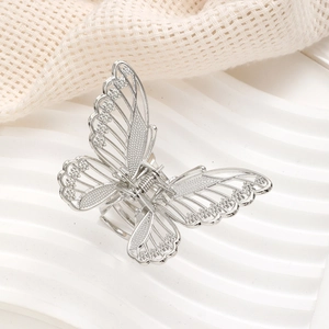 Macro view showing hollowed-out butterfly hair claw with shimmering rhinestones and silver finish