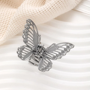 Detailed view of silver hollow butterfly hair claw clip with intricate metallic texture