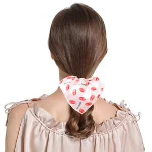 Pink satin scrunchie with red lip prints and Passion text on a ponytail