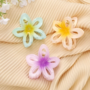 Trois pinces à cheveux fleur de frangipanier en acrylique coloré sur tissu beige