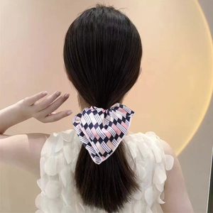 Detail view of navy and pink checkerboard floral bow scrunchie on a ponytail