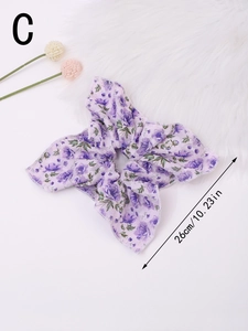 Detail of a large purple floral scrunchie hair tie featuring a soft bow-knot design