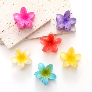 Macro detail of six colorful gradient plumeria hair clips in matte translucent resin