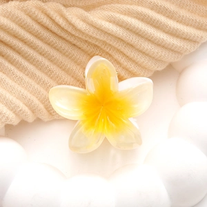 Macro detail of the acrylic plumeria flower hair claw with a realistic resin texture