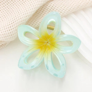 Détail d'une pince à cheveux fleur bleu clair avec un ressort en métal doré