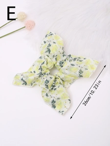 Detail of floral chiffon hair scrunchie with long ribbon bow on soft white fur background
