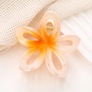 Vue détaillée d'une pince à cheveux fleur dégradée pêche avec ressort doré robuste