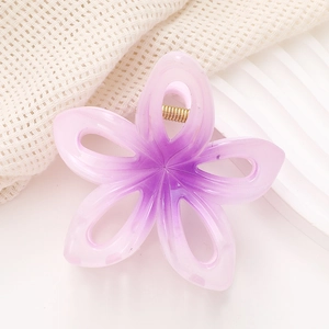Gros plan sur la pince à cheveux fleurie violette dégradée avec ressort doré robuste