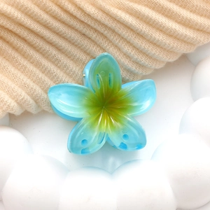 Detailed macro view of the sky blue acrylic plumeria flower hair claw clip texture