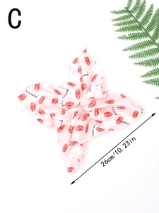 Detail of a large 26cm pink satin scrunchie with red lip prints and passion text