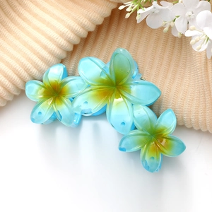 Détail de la pince à cheveux fleur dégradé bleu et jaune avec finition acétate brillante
